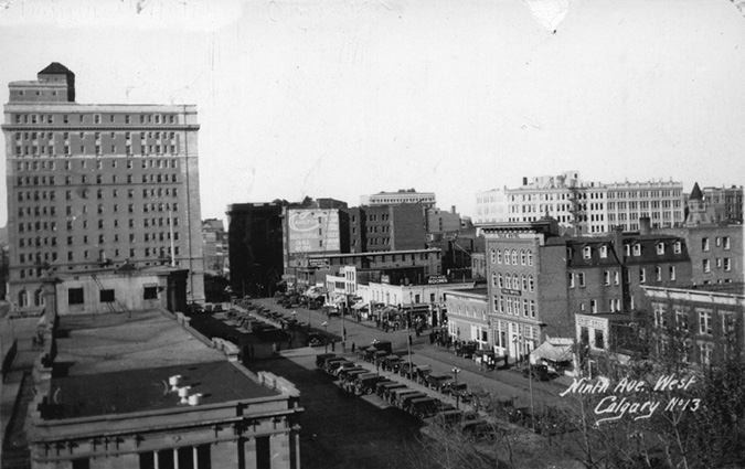 Figure 4-1 “9th Avenue SW, Calgary Alberta, Palliser Hotel and Canadian Pacific Railway Station”. Black and white reproduction of a postcard of 9th Avenue SW. On the left-hand side of the picture is the CPR station in the foreground with the Palliser Hotel at the back. Across the street is the beginning of a string of hotels and establishments along Atlantic Avenue, more informally known as “Whisky Row” for the omnipresence of establishments that serve liquor as well as becoming the location where a number of stock brokers and oil companies began selling shares to recent out-of-town arrivals from the train station.