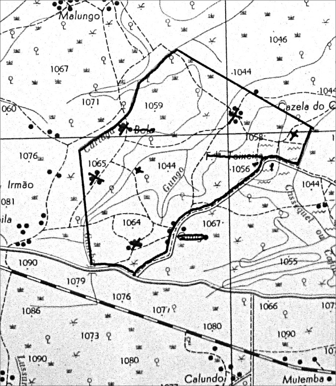 Black and white map extract. A large irregular property is outlined in the centre of the map. Names of villages inside and around this shape are crossed out, with black X’s over where they were. Topographic lines and small illustrations of grasses are visible across the map. 