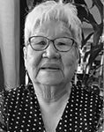 Black and white photograph: Portrait of a woman wearing glasses and a polka dot shirt.