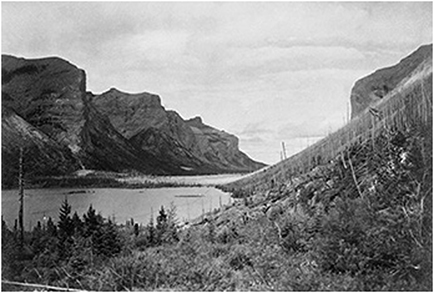 Lake Minnewanka looking towards Devils Gap with mountains on either sides.