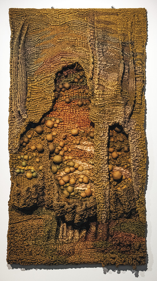 Photo: large vertical rectangle piece in brown and orange. It is rough and textured with hanging pieces over nubby bits. 