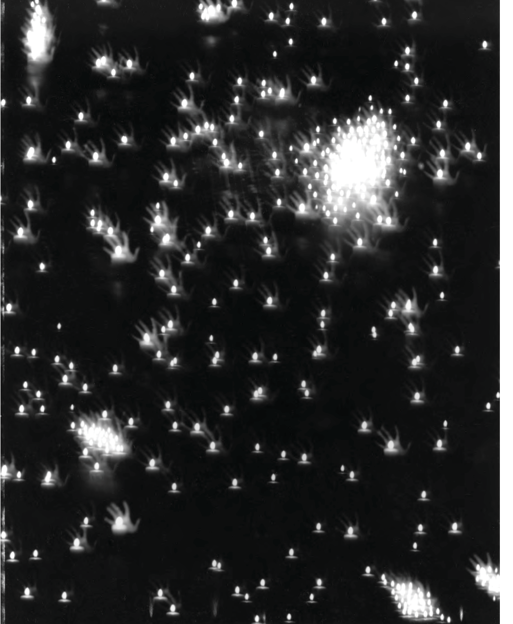 Black and white photograph: Pinhole photograph of a galaxy, made up of multiple identical candle flames and hands.