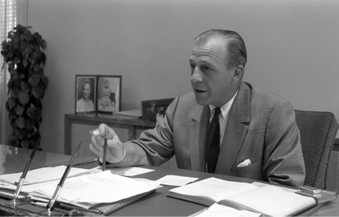 Twaits was president and subsequently Chair of the Board of Imperial Oil in the 1960s and early 1970s. In contrast to many other executives he was outspoken and opinionated in public as well as in private. In this photo he is seated behind a desk surrounded by papers and account books.