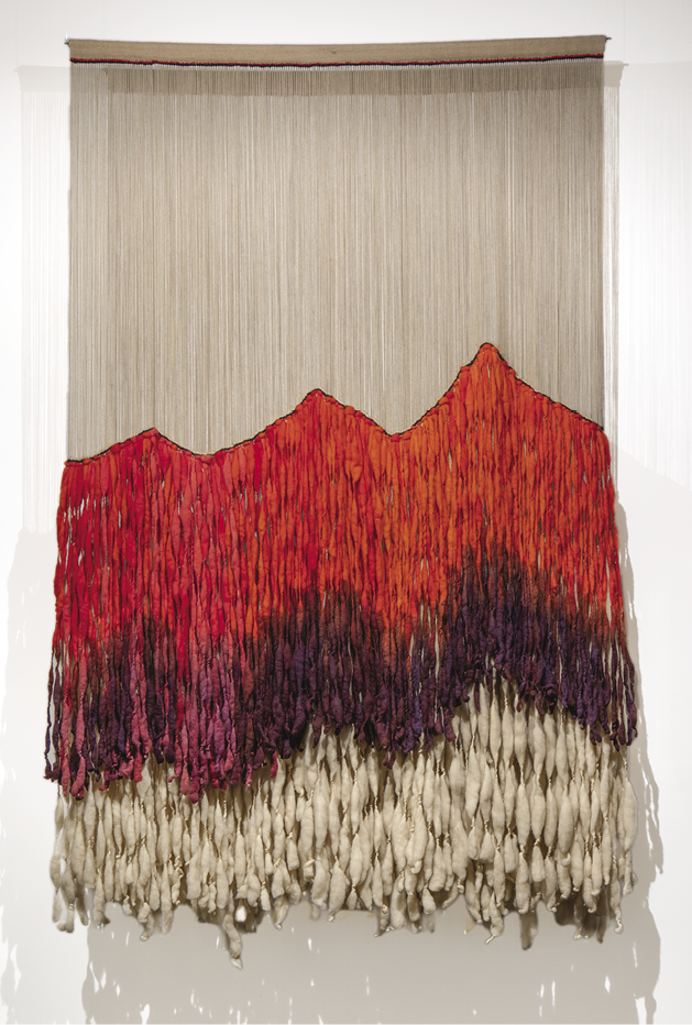 Photo: off-white, red, and dark purple hanging of long strings with the colour bunching up into shapes of mountains.