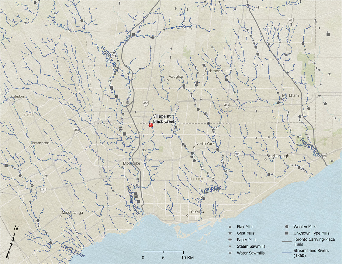 Colour map. Map of the greater Toronto area, highlighting the numerous rivers and tributaries. Mills are indicated by a variety of grey shapes for different types of mills, and are concentrated around the Credit, Humber, Don, and Rouge Rivers. The location of The Village at Black Creek is in the centre of the map, indicated with a red dot.
