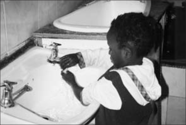 A child washes his hands in a wash basin.