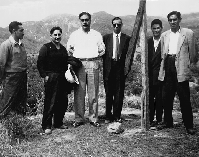 Government and union officials pose at the top of a hill, next to a landmark used to fraction hacienda lands and distribute plots to miners and peasant in Cochabamba.