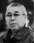 Black and white photograph: Portrait of a man wearing glasses and a collared shirt