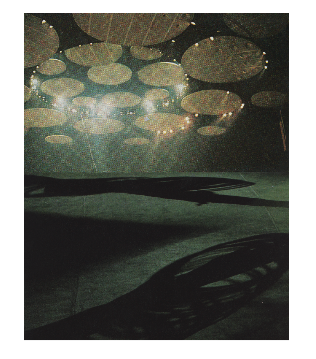 Colour photo collage: The underside of a huge spaceship above a landscape.