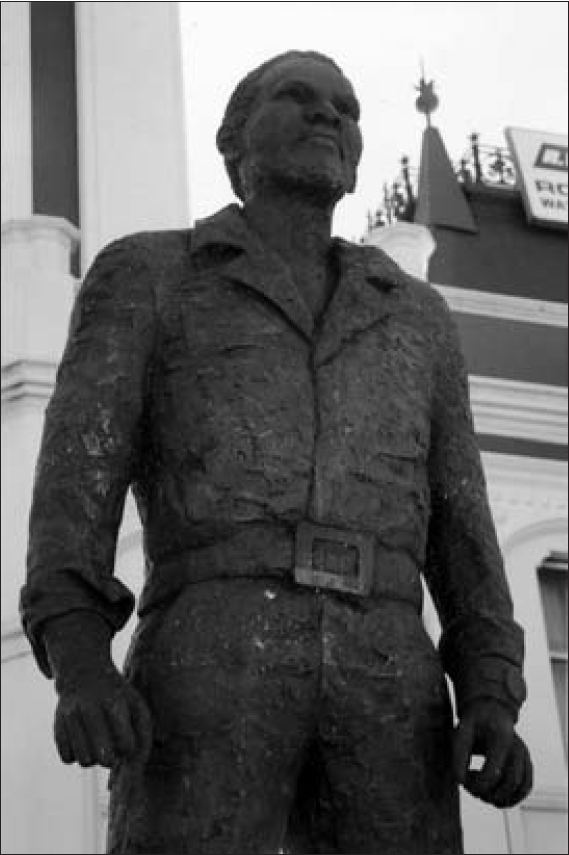 A statue of Steve Biko in front of a white building.