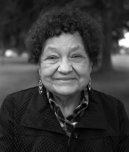 lack and white photograph: Adult Indigenous woman from the chest up, smiling