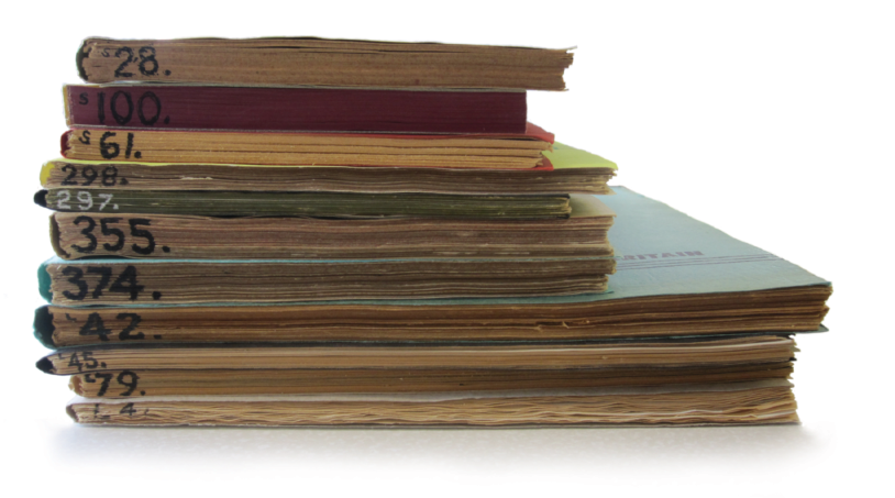 Colour photograph: A stack of notebooks, with numbers written across the bottom edge of each.