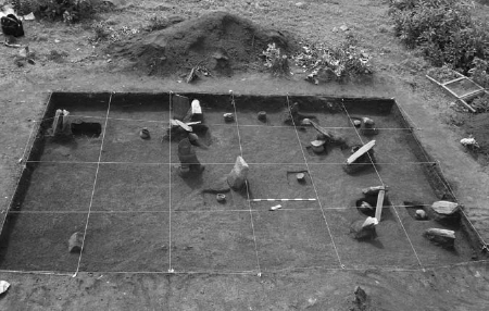 A wire mesh encloses a rectangular excavation area in a grid-like fashion.