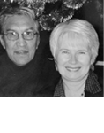 Black and white photograph: Photograph of a man with glasses next to a woman with earrings with sparkly decorations in the background. 