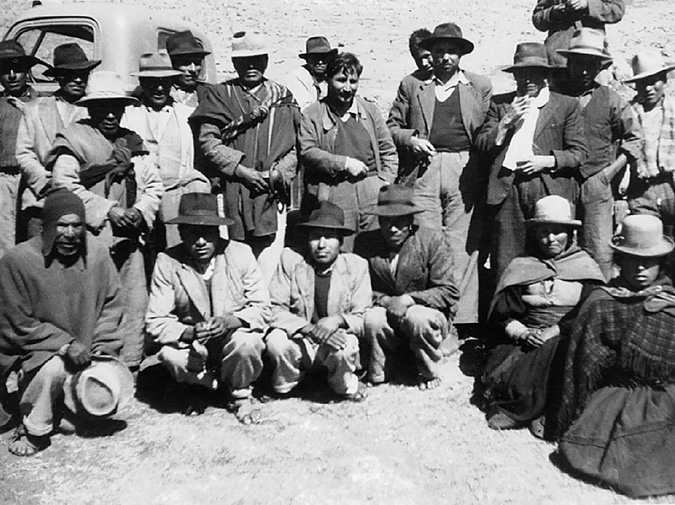 A peasant union leader and a government official pose surrounded by highland community leaders.