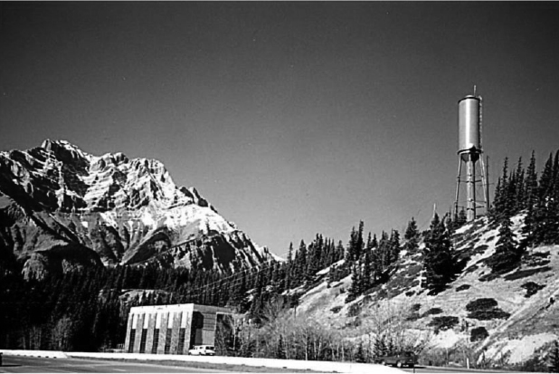 The Cascade powerplant. There are snow capped mountains and a high raised tank in the background.