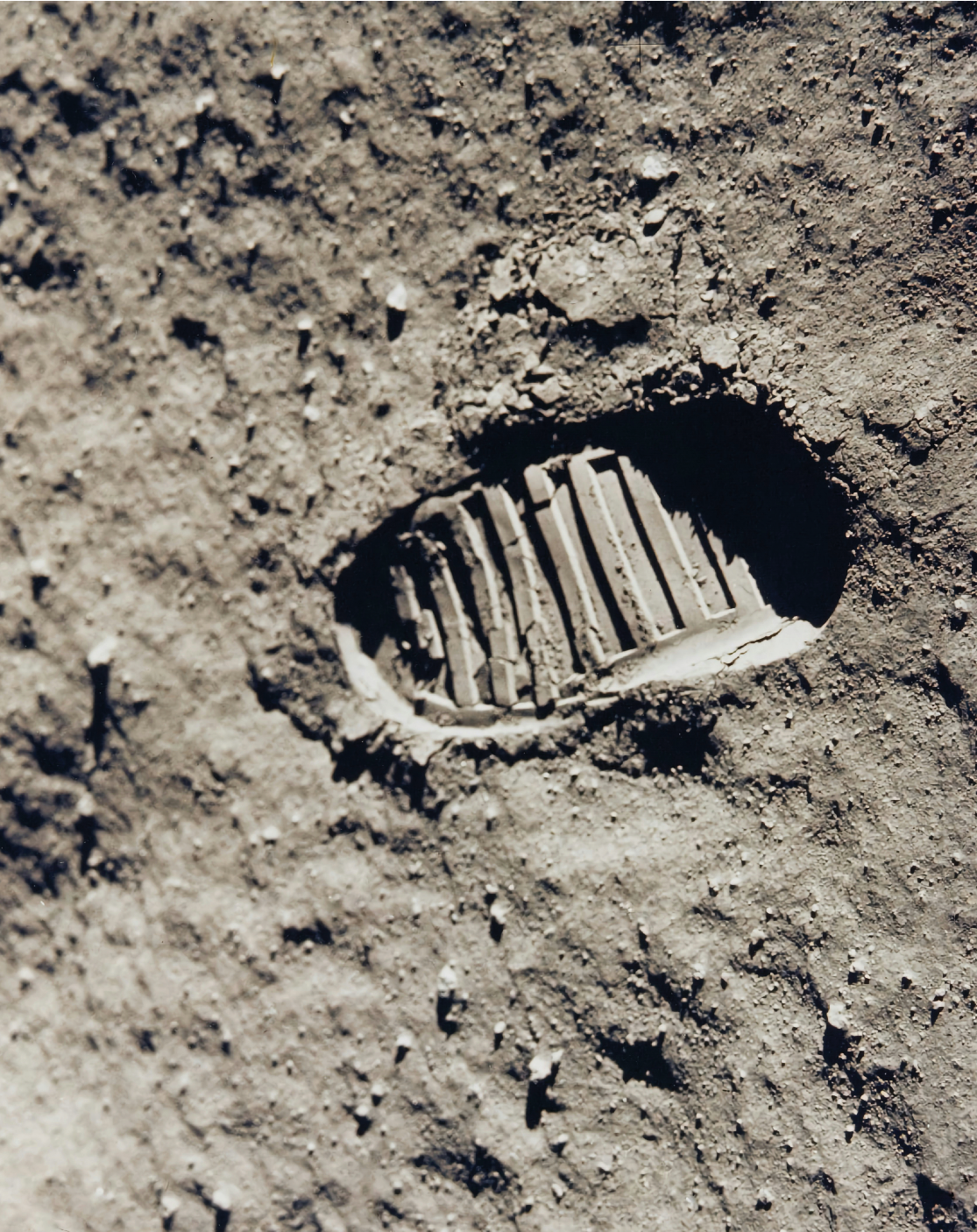 Black and white photograph: The imprint of an astronaut’s book on the moon’s surface.