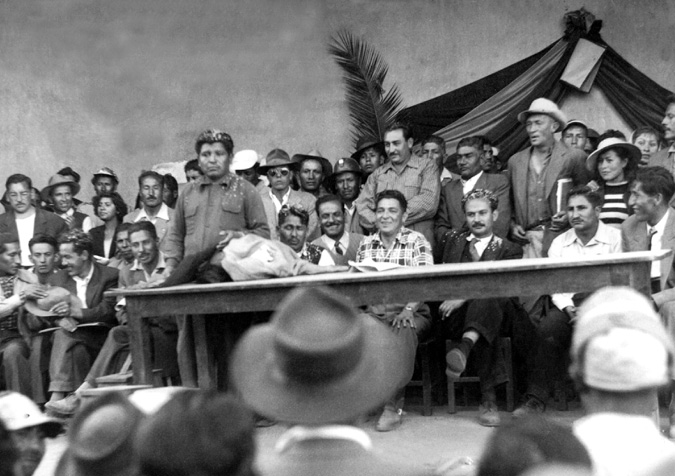 Government and union officials pose at the top of a hill, next to a landmark used to fraction hacienda lands and distribute plots to miners and peasant in Cochabamba.