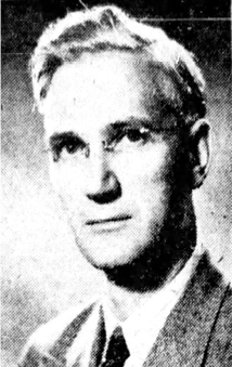 Black and white photograph: A black and white portrait of an older man with light hair, dressed in a suit and tie, looking directly at the camera with a neutral expression.