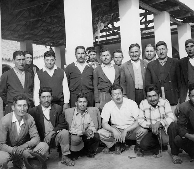 A government official pose surrounded by peasant leaders in a rural town’s market.