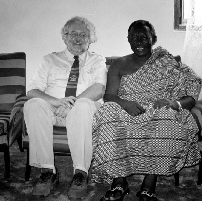 A black and white photograph of John Kufuor of Ghana (right) at his family house in Kumasi with Prof. Don Ray (left) both sitting on a couch.