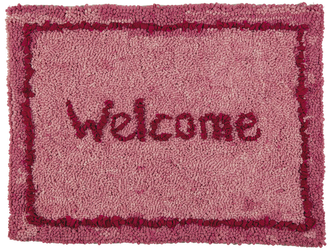 Photo: pink welcome mat with a red border and red lettering spelling out, “Welcome.”