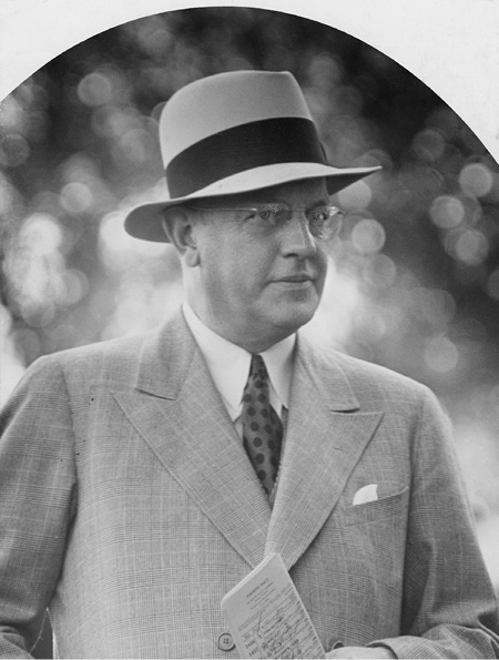 Smith was president of the International Petroleum Company in the 1920s and then headed Imperial Oil in the 1930s. In this photo, he wears glasses, a hat, and a light double breasted suit.