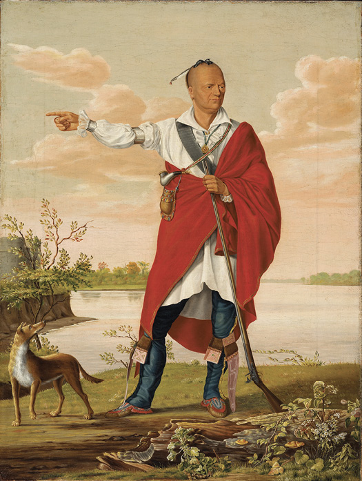 Colour painting. Full body portrait of an Indigenous man standing in front of a lake. He is wearing a white shirt, a red blanket as a coat, silver armbands, and moccasins. His head is partially shaved at the sides and he wears a single feather hanging down from the hair at the top of his head. He is holding a musket in his left hand and is pointing with his right. He is looking to his left, while a dog stands at his right looking at him.