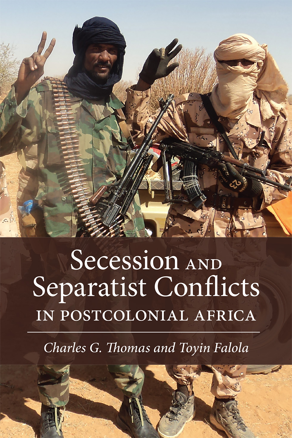 Cover: Two Touareg secessionists stand side by side in the desert landscape of Mali. The one on the left wears green camouflage and his face is visible, the one on the right wears beige camouflage and has his face covered with a beige scarf. Both carry machine guns in one hand, while flashing peace signs with the other.