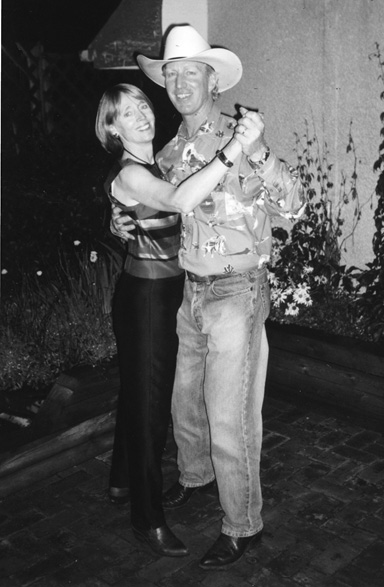 Black and white photograph of Ted and Bambi Morton dancing outside at the “No More ‘Sober Second Thought’” Stampede Party. Ted and Bambi are smiling towards the camera and Ted is wearing a cowboy hat.