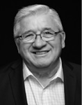 Black and white photograph: Portrait of a man wearing glasses, a collared shirt, and a suit jacket. 