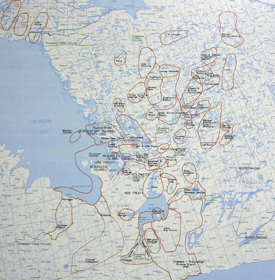 Colour map. Map of the land around Georgian Bay and Lake Simcoe, with many lakes and rivers shown in blue. This area is covered by many areas outlined in brown with names in them, indicating traditional family hunting territories.