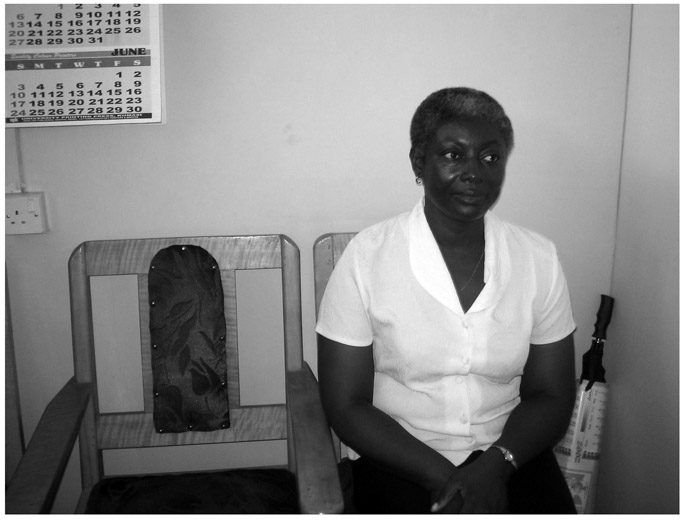 A black and white photograph of Doctor Wilhemina Donkoh, sitting on a wooden chair in a room.