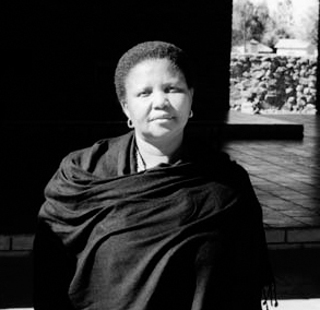 A black and white photograph of the first woman paramount chief in Botswana wearing a black shawl.