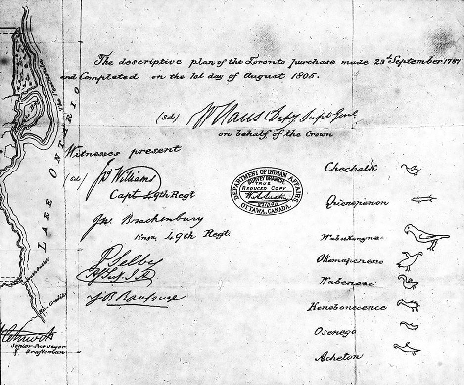 Black and white image. Snippet from a nineteenth-century treaty document. Several signatures are at the bottom of the document. On the left are signatures with military ranks, and on the right are the names of the Mississauga signatories, with their Doodem animals drawn beside them. On the left is part of a map of Lake Ontario. In the middle is a stamp of the Indian Affairs Department certifying that it is a true copy.