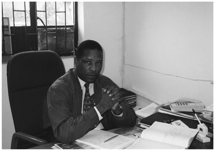 A black and white photograph of inkosi BA Makhanya of Sobonakhona Makhanya TA, sitting at his desk in his office.