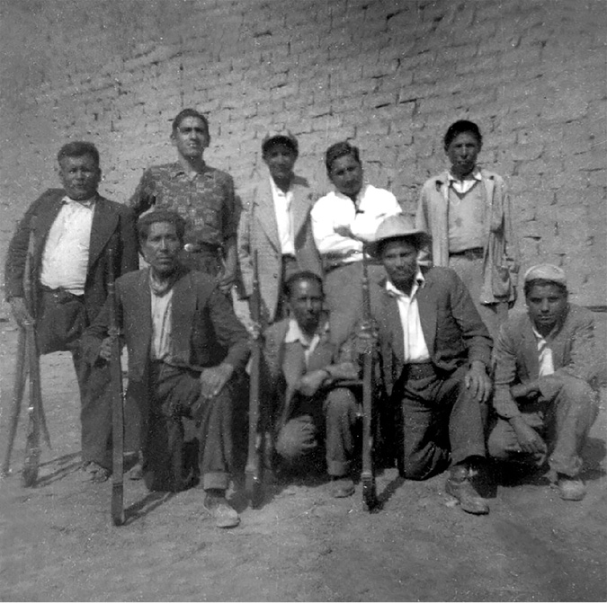Peasant union leaders pose surrounded by armed militiamen in a valley peasant central.