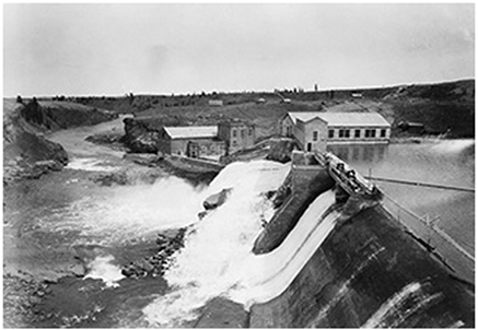 Aerial image of Horseshoe Falls Dam on the Bow River, with a Powerhouse in the background.