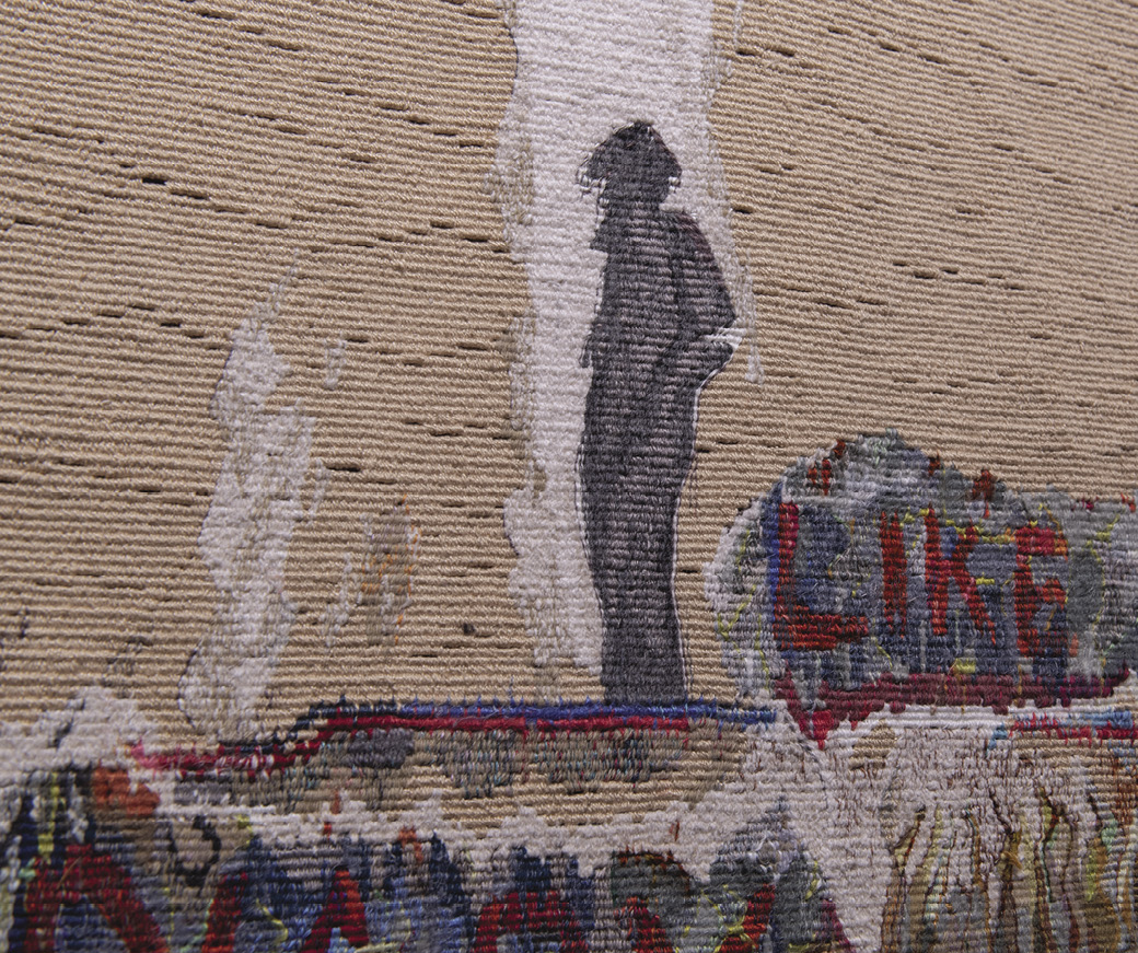 Photo: detail of a weaving with a shadowed figure at center on blue-red ground that appears to smoke. The word “like” is spelled out in a bush behind him