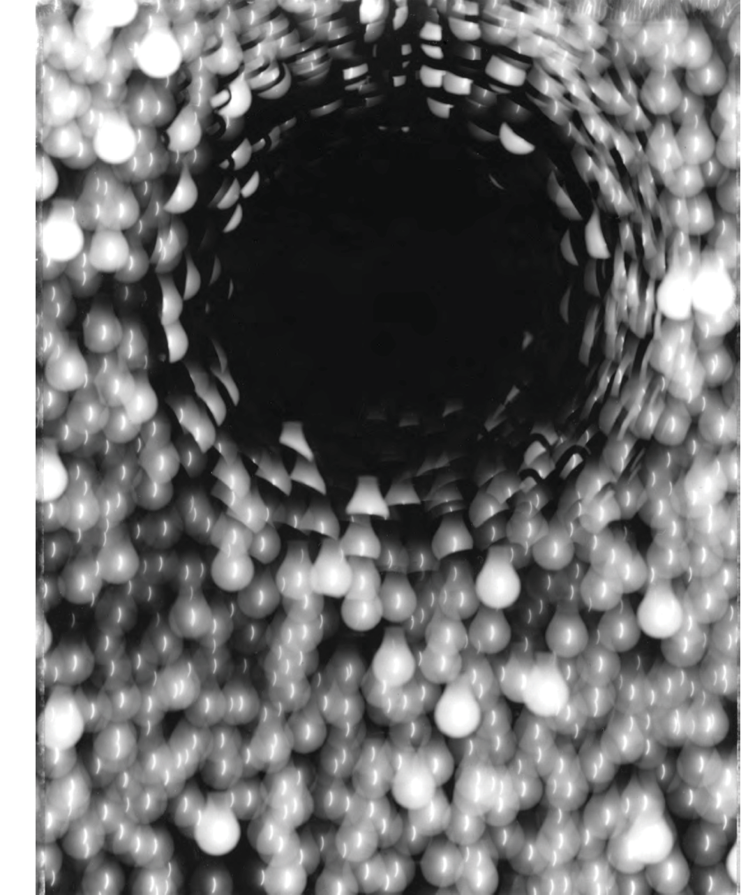 Black and white photograph: Pinhole photo of a cluster of stars, made up of the image of light bulbs.