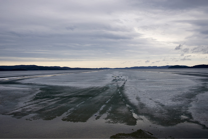A frozen Lake Athabasca is beginning to melt, ice crystals are loosening and fracturing thought the solid look of the lake maintains a stillness and quiet, though the moving and shifting ice breaks the silence occasionally.