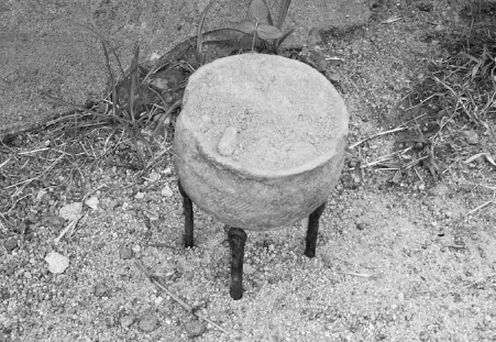 Three iron points or sticks used as support for a pot.